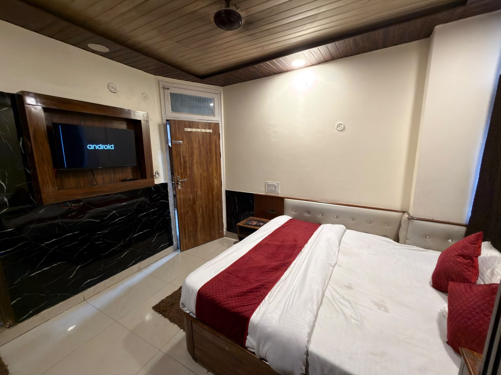 Double bed room with the TV unit and entrance door