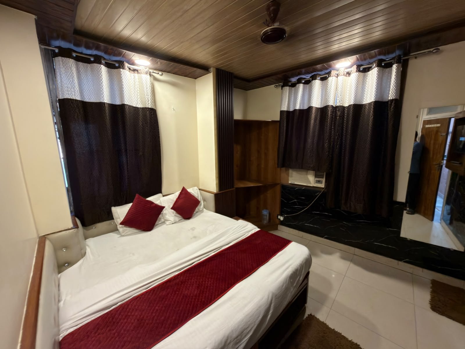 Double bed room, wide view with curtains and mirrored wardrobe