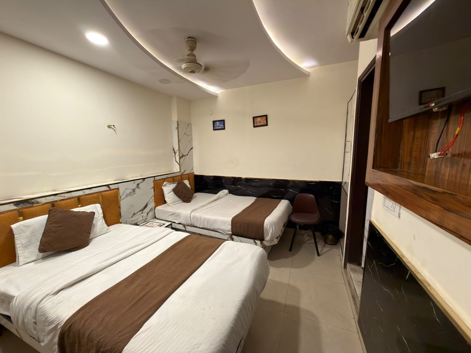 Twin bed room at Hotel Vin Inn seen from the doorway, with TV and wall-mounted AC