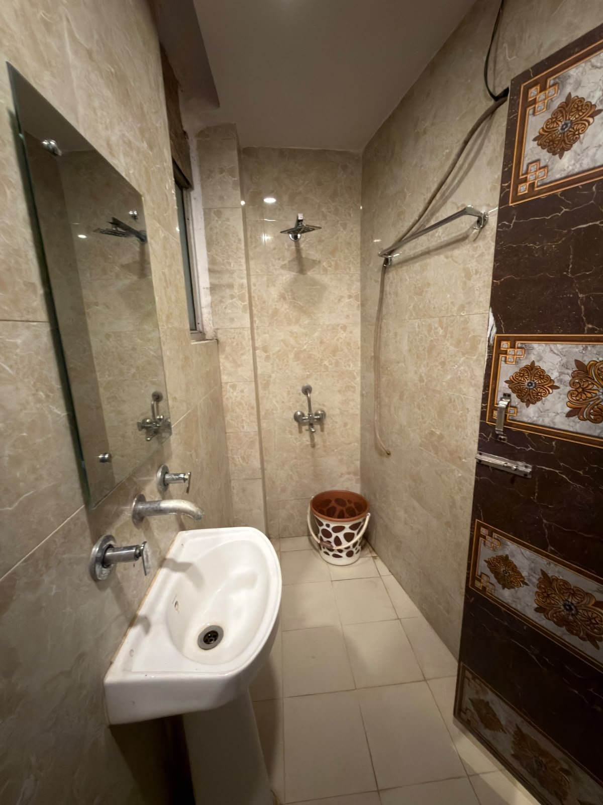 Attached bathroom shower area with basin and mirror